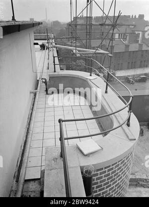 Des travailleurs de Val de travers Asphalt Limited , une entreprise de pavage , travaillant sur le revêtement du toit de l'hôpital juif de Londres à Stepney Green . 1938 Banque D'Images