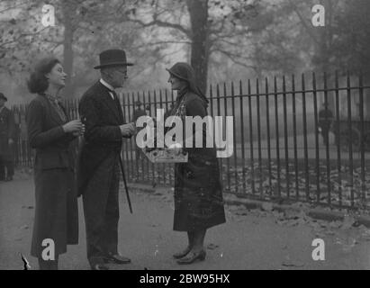 Le premier ministre achète son pavot lors de sa marche matinale le jour de l'armistice . Le premier ministre a fait sa promenade matinale au parc Saint-James le jour de l'armistice , au cours de laquelle il a acheté son pavot à soeur L Calvert de la Croix-Rouge Royale . Le premier ministre achète son coquelicot à sœur L Calvert lors de sa promenade matinale à St James Park , Londres , avec sa plus jeune fille . 11 novembre 1932 Banque D'Images