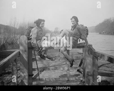 La joie de la route à Pâques . Deux jeunes randonneurs qui ont voyagé dans le Mystery Express de Londres à Pangbourne , un endroit de beauté côté de la Tamise , en appréciant un repos sur une porte à côté de la route au soleil de printemps . 25 mars 1932 Banque D'Images