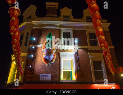 Wardour Street dans la ville chinoise de Londres avec un dragon chinois et des lanternes accrochées au mur de brique d'un magasin. Londres Banque D'Images