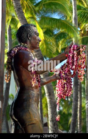 Statue du duc Paoa Kahanamoku en hommage à l'un des héros de Waikiki. leis de fleur pendent de ses mains étirées. Banque D'Images