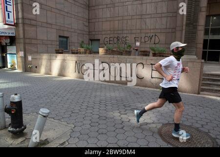 New York, New York, États-Unis. 30 mai 2020. Un jogging passe devant le tribunal des criminels de Center Street à New York, à la suite d'un mur charpeux marqué comme le résultat d'une manifestation et d'un rassemblement de la Justice pour GEORGE FLOYD à New York, New York. Plusieurs dommages matériels résultant de la manifestation peuvent être constatés dans toute la ville. Crédit : Brian Branch Price/ZUMA Wire/Alay Live News Banque D'Images