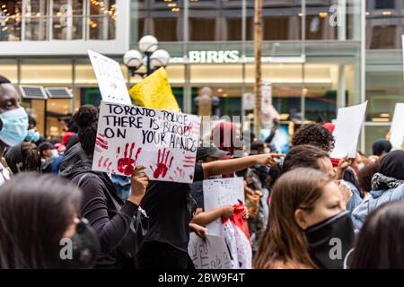 Des milliers de personnes défilent dans le centre-ville de Toronto pour demander justice après la mort de Regis Korchinski-paquet, une jeune femme noire tombée de son balcon. Banque D'Images