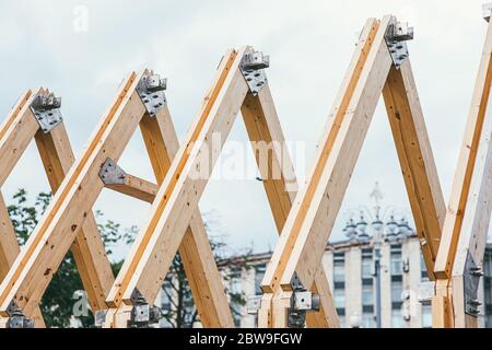 Chevrons en bois de toit non fini sur fond de ville et ciel blanc. Le concept de construction et de création de nouveaux logements Banque D'Images