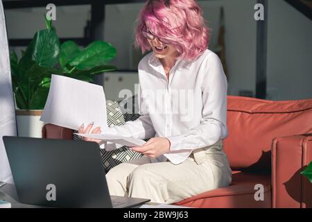 Souriante jeune femme en ligne enseignant rose cheveux vidéo zoom appel à la maison bureau. Banque D'Images