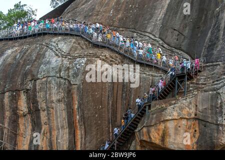 Les visiteurs du rocher de Sigiriya au Sri Lanka, également connu sous le nom de forteresse du lion, grimpent les escaliers qui mènent au sommet des rochers et en viennent. Banque D'Images