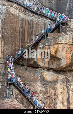 Un ruisseau de personnes escalade l'escalier de la plate-forme du Lion vers le sommet de la forteresse du Rocher Sigiriya dans le centre du Sri Lanka. Banque D'Images