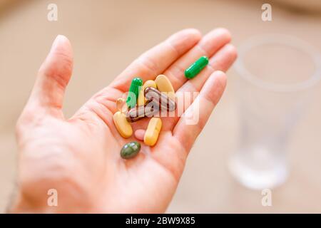 Le système immunitaire boossera avec des vitamines. Pilules pharmaceutiques colorées, stupéfiants et vitamines en capsules sur la paume. Copier l'espace pour le texte. Banque D'Images