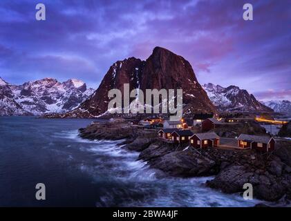 Une photo de longue exposition fascinante de village de pêche illuminé avec des maisons de rorbu sous le ciel violet à Homnoya, île Lofoten, Norvège Banque D'Images