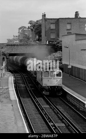 Locomotive diesel de classe 33 n° 33212 à Caledonian Road et à la gare de Barnsbury avec un train pétrolier en direction de l'ouest, Londres, Royaume-Uni. 8th septembre 1986. Banque D'Images