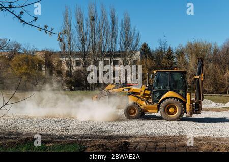 Dnepro-culudnoe/Ukraine - avril 08 2020 : un tracteur verse le gravier du godet Banque D'Images