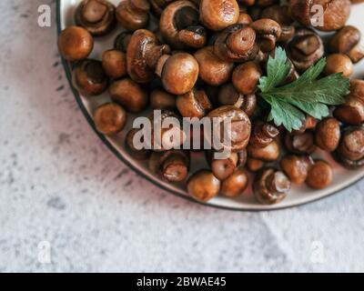 Mini-champagnes frits prêts à consommer sur plaque avec espace de copie. Parfait tas de mini champignons sur plaque sur fond de ciment gris. Vue de dessus ou plan d'étapage. Banque D'Images
