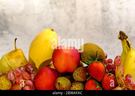 Assortiment de fruits exotiques dans un panier métallique isolé sur blanc Banque D'Images