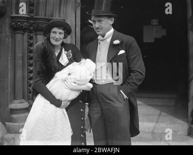 M. et Mme FA Gardiner et leur fils bébé après le baptême du bébé à l' église Saint-Marc , Regent' s Park , Londres . M. Gardiner est le célèbre joueur écossais de rugby et Cambridge Blue . 12 avril 1935 Banque D'Images