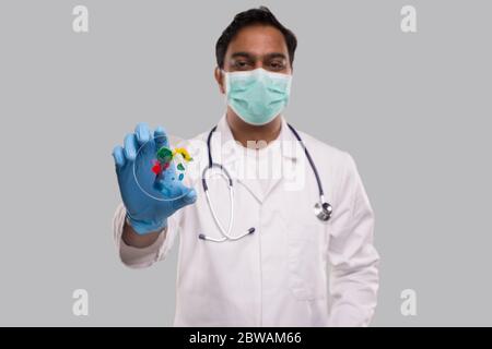 Médecin tenant une boîte de Petri portant un masque médical et des gants isolés. Médecine, concept de la science Banque D'Images