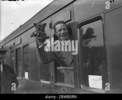 À la gare de Waterloo , à son retour aux États-Unis , l' acteur américain , Joe E Brown , avec son petit chien . 1936 Banque D'Images