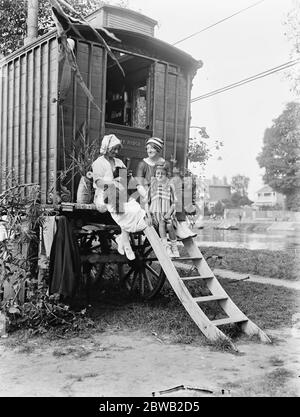 Deux familles ne peuvent pas trouver d'hébergement à Londres, ont loué une caravane et des tentes et sont campées sur la rive de la rivière à Staines . La caravane ' Vimy Ridge et certains des occupants 13 août 1919 Banque D'Images