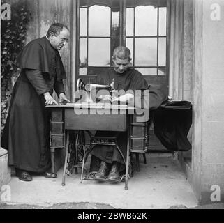 La prouesse de construction de Monk . Salle et partie de l'église érigée par lui-même à Hayes dans Middlesex . Frère Raymond , le constructeur de moine . Dans cette photo, il est vu au travail sur la machine à coudre . 1er septembre 1922 Banque D'Images