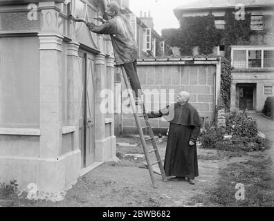 La prouesse de construction de Monk . Salle et partie de l'église érigée par lui-même à Hayes dans Middlesex . Frère Raymond , le monk constructeur , est vu sur l'échelle . 1er septembre 1922 Banque D'Images