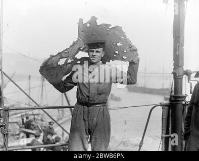 Le Grand raid naval sur Zeebrugge . Un homme d'équipage à bord du HMS vindicatif un croiseur britannique protégé . Le 23 avril 1918, elle était en action féroce à Zeebrugge quand elle est allée aux côtés de la Mole et ses travaux sont gravement endommagés . Un marin britannique tenant un morceau de plaque blindée montrant certains des dommages . 1918 Banque D'Images