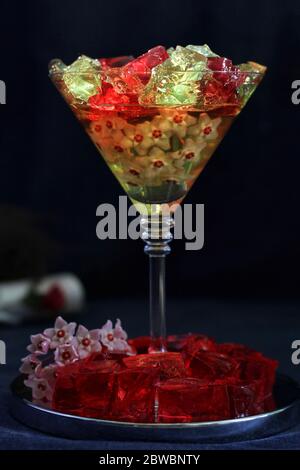 Dessert en gelée douce, cuisine design, repas créatifs avec fleurs de vanille d'humeur sombre sur fond noir Banque D'Images