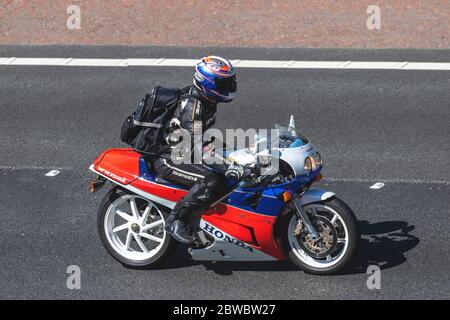 Honda VFR 750R. Arak Helmet, vêtements de messagerie; motard; transport à deux roues, motos, véhicule, routes, motos, motards motorisés sur l'autoroute M6 Chorley, Royaume-Uni Banque D'Images