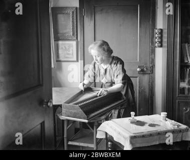 Préparation au festival Haslemere de musique de chambre ancienne . Famille célèbre qui font des instruments de temps vieux . Mme Dolmetsch , qui fait les superbes décorations florales caractéristiques de beaucoup de ces instruments anciens , est ici vu ornement d'un virginal . 23 janvier 1925 Banque D'Images