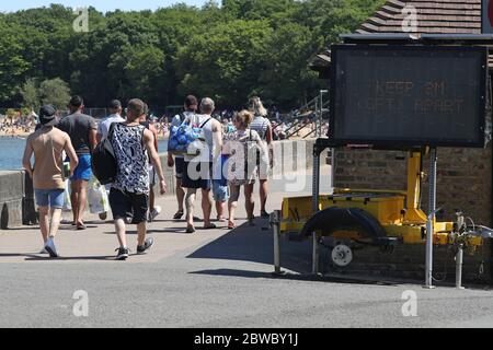 Un signe rappelant aux gens les mesures de distanciation sociale au Ruislip Lido à Londres, alors que l'Angleterre relâche ses restrictions de verrouillage du coronavirus. Banque D'Images