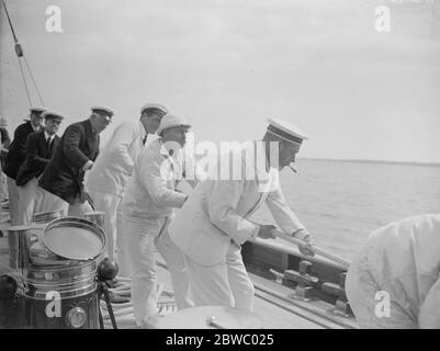 Le Roi prend la roue de son yacht Britannia . Le roi aide à transporter le spinnaker . 7 août 1924 Banque D'Images