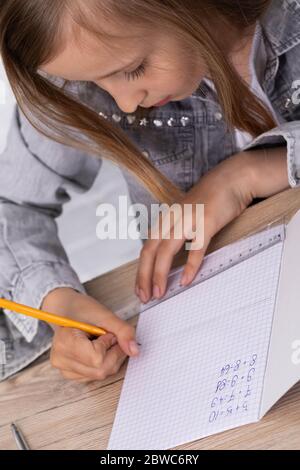 L'étudiant utilise une règle et un crayon pour tracer des lignes qui constituent la solution à la tâche donnée dans la leçon. Banque D'Images