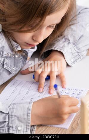 L'étudiant utilise une règle et un crayon pour tracer des lignes qui constituent la solution à la tâche donnée dans la leçon. Banque D'Images