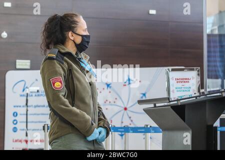 Gdansk, Pologne 29 mai 2020 un officier de la sécurité de l'aéroport (sol) portant un masque et des gants est vu à l'aéroport Lech Walesa de Gdansk, Pologne le 29 mai 2020 l'aéroport de Gdansk se prépare à accepter le premier avion après la reprise des vols intérieurs à partir du 1er juin de cette année. La circulation aérienne a été suspendue à la mi-mars 2020 en raison d'une pandémie de coronavirus. Chaque passager aura sa température mesurée à l'aide d'une caméra thermique, seuls les passagers seront autorisés à entrer dans le terminal de l'aéroport. © Vadim Pacajev / Alamy Live News Banque D'Images