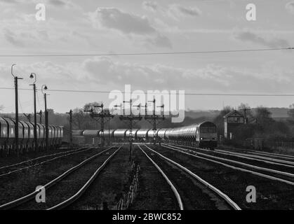 DB locomotive diesel de classe 60 de fret transportant un long train de marchandises de réservoirs d'huile par les signaux mécaniques du sémaphore à Wrawby Junction, Barnetby Banque D'Images