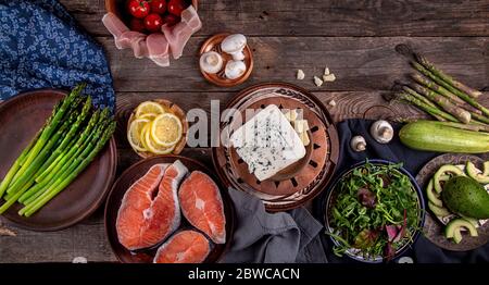 Composition en hauteur de différentes assiettes avec repas pour la cuisine préparation du dîner : asperges, saumon, bacon, champignons, tomate, courgette, avocat etc Banque D'Images