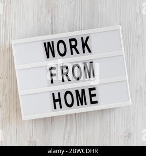 « travailler à domicile » sur une visionneuse sur fond blanc en bois, vue de dessus. En hauteur, par dessus, plat. Banque D'Images