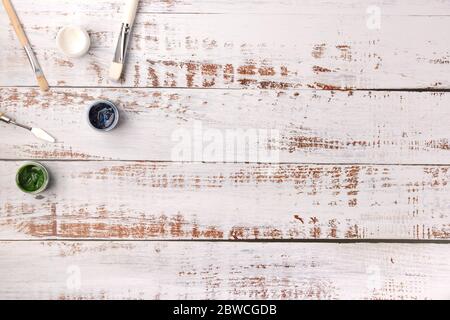Peintures et pinceaux sur bureau en bois blanc, vue sur le dessus Banque D'Images