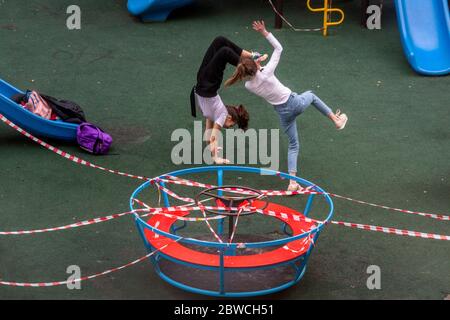 Moscou, Russie. 25 mai 2020 les filles jouent sur le terrain de jeu public fermé dans la cour d'un immeuble résidentiel lors de l'épidémie de coronavirus COVID-19 à Moscou, en Russie Banque D'Images