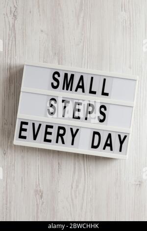 « petit pas tous les jours » sur une visionneuse sur fond en bois blanc, vue du dessus. Au-dessus, par le dessus, à plat. Banque D'Images