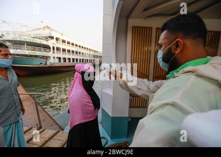 Dhaka, Bangladesh. 31 mai 2020. Un employé de traversier vérifie la température corporelle d'un passager au terminal de lancement de Sadarghat, à Dhaka, au Bangladesh, le 31 mai 2020. Le Bangladesh est partiellement responsable d'un confinement de plus de deux mois en raison du nouveau coronavirus (COVID-19) de mai 31, à un moment où le pays est confronté à la pire crise de la COVID-19. Crédit: Suvra Kanti Das/ZUMA Wire/Alay Live News Banque D'Images