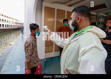 Dhaka, Bangladesh. 31 mai 2020. Un employé de traversier vérifie la température corporelle d'un passager au terminal de lancement de Sadarghat, à Dhaka, au Bangladesh, le 31 mai 2020. Le Bangladesh est partiellement responsable d'un confinement de plus de deux mois en raison du nouveau coronavirus (COVID-19) de mai 31, à un moment où le pays est confronté à la pire crise de la COVID-19. Crédit: Suvra Kanti Das/ZUMA Wire/Alay Live News Banque D'Images