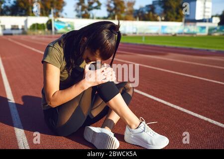 Blessure au genou pendant l'entraînement.Fille a blessé sa jambe pendant l'exercice. Banque D'Images