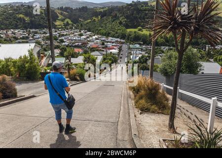 Homme sur la rue Baldwin la rue la plus raide du monde à Dunedin, Otago, Nouvelle-Zélande. Banque D'Images