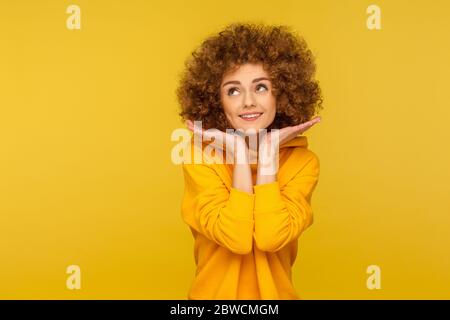 Portrait de la jeune femme enjouée à poil dur en sweat à capuche de style urbain montrant son visage frais et propre avec maquillage, beauté et soin de la peau concept. indo Banque D'Images