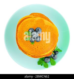 Tas de crêpes de citrouille avec des bleuets et de la menthe sur une assiette turquoise isolée sur blanc Banque D'Images