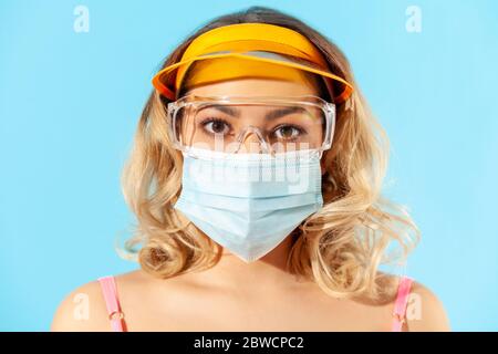 Gros plan femme visage portant un masque chirurgical hygiénique, lunettes de protection pour prévenir le coronavirus contagieux, menace de pandémie de covid-19 et protection RE Banque D'Images