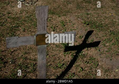 Une croix en bois jette une ombre au cimetière de West Norwood le 30 mai 2020 dans le sud de Londres, au Royaume-Uni. Photo de Sam Mellish Banque D'Images