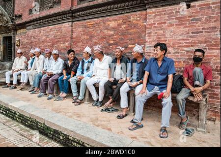 PATAN, LALITPUR, NÉPAL - 15 AOÛT 2018 : des hommes âgés non identifiés de nouveau-né sont assis devant le Palais royal de Mul Chowk, sur la place Patan Durbar - Népal Banque D'Images