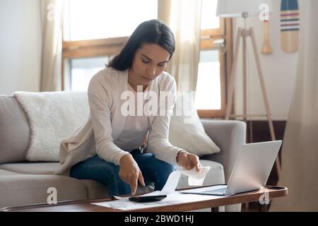 Jeune femme au foyer calculer les finances payer des factures en ligne Banque D'Images