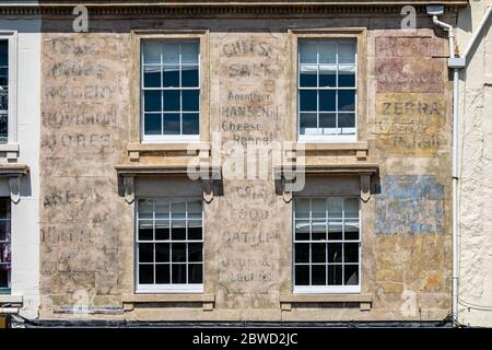 Des affiches publicitaires anciennes de détail du début des années 1900 peintes sur le mur du bâtiment au sommet de Catherine Street, Frome, Somerset, Royaume-Uni, le 31 mai 20 Banque D'Images