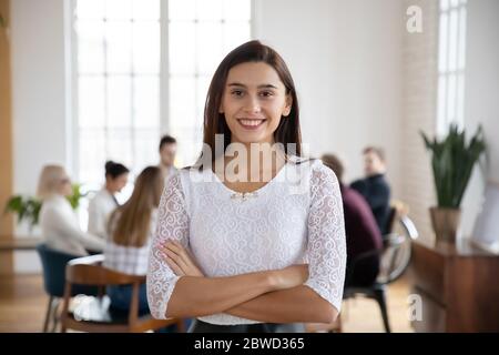 Portrait d'un jeune employé souriant, debout dans un bureau moderne. Banque D'Images